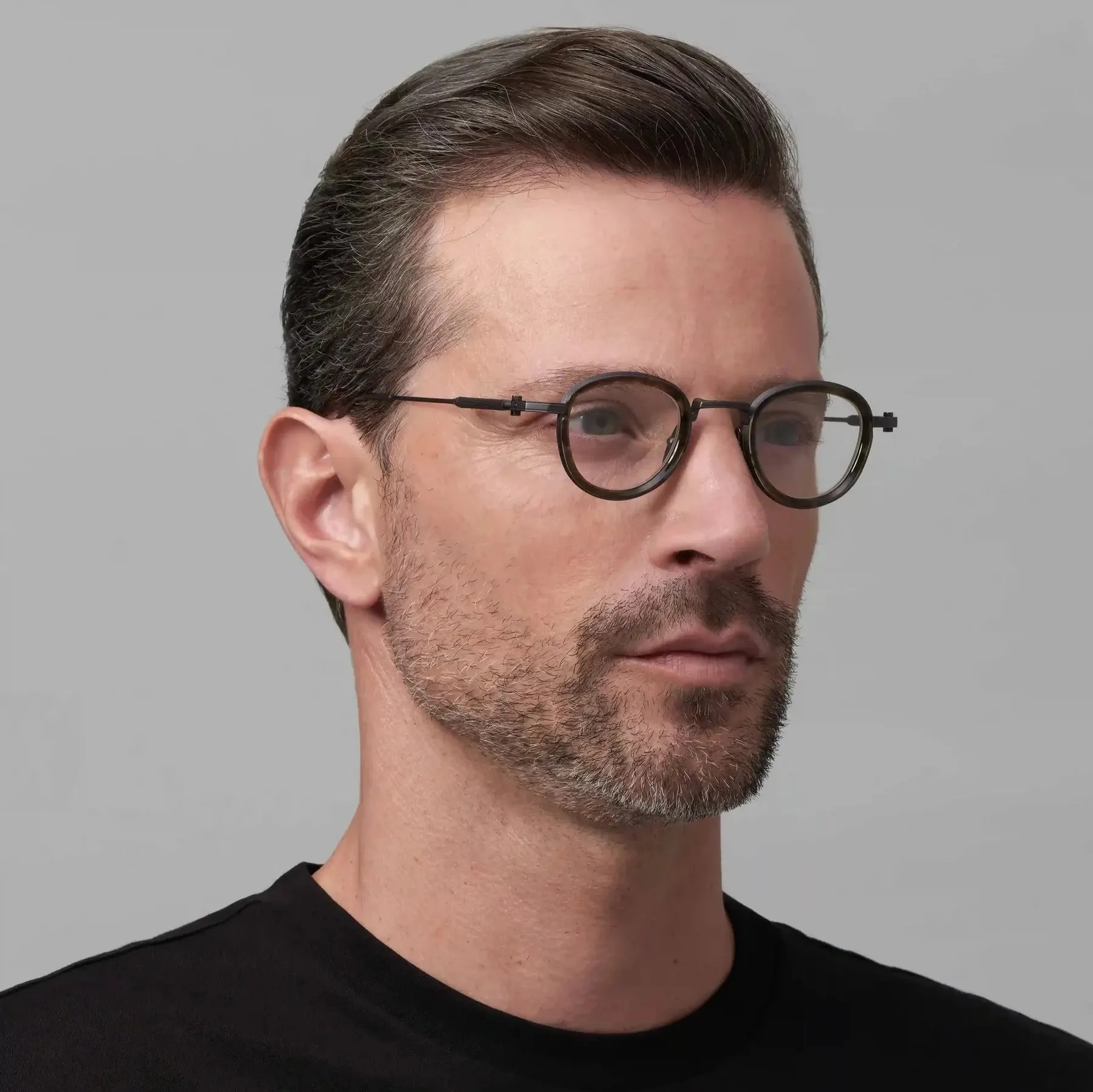 Man wearing Akoni Agile optical glasses in Black Iron/Green Tortoise Swirl, three-quarter view