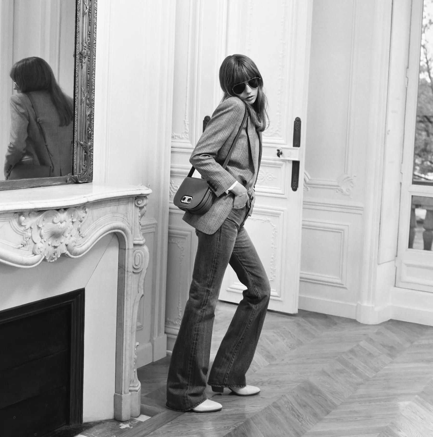 Celine Triomphe campaign, Spring-Summer 2020: Fran Summers in sunglasses with a Triomphe bag, by a fireplace