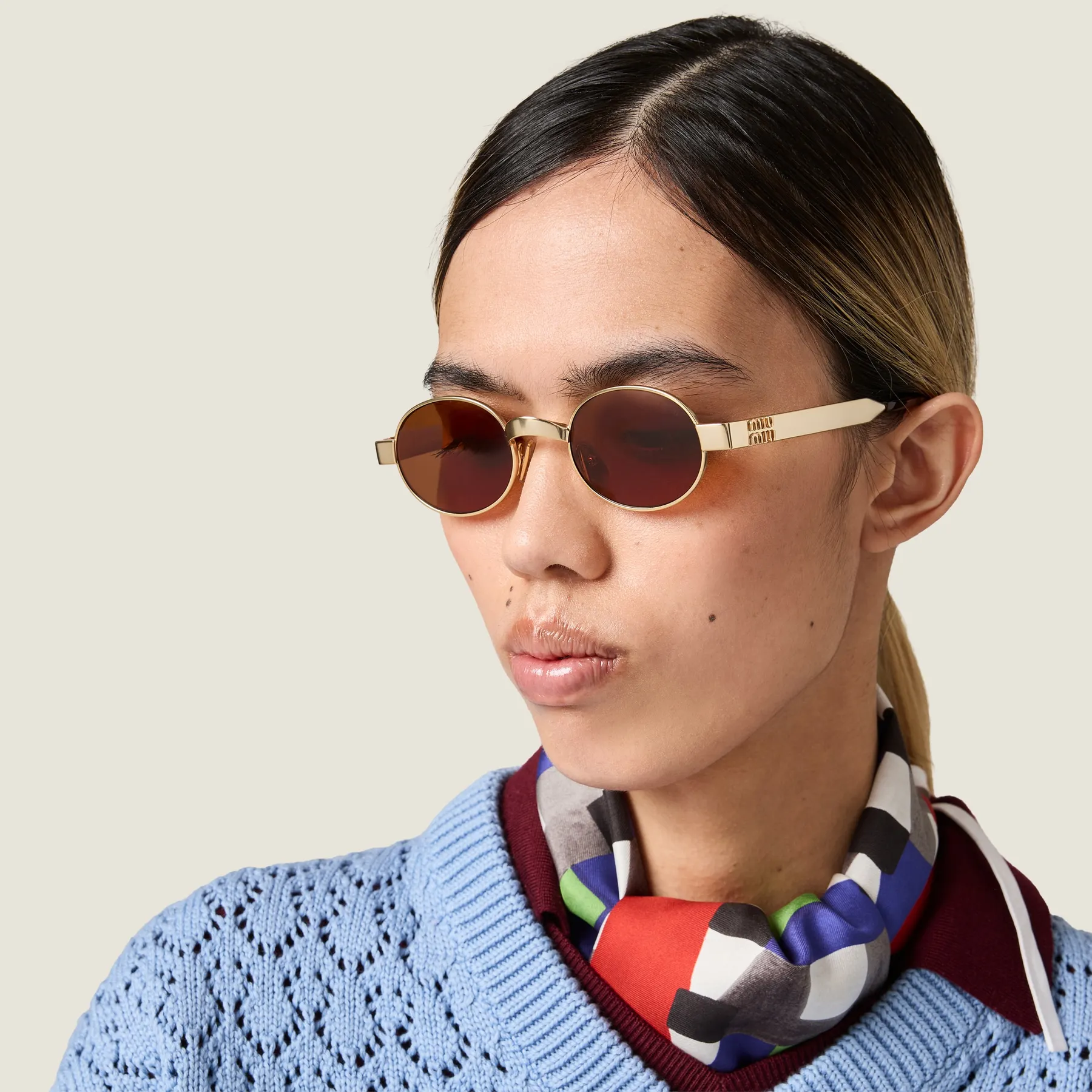 Model wearing Miu Miu Envie MU B51S in Antiqued Gold with Tamarind lenses