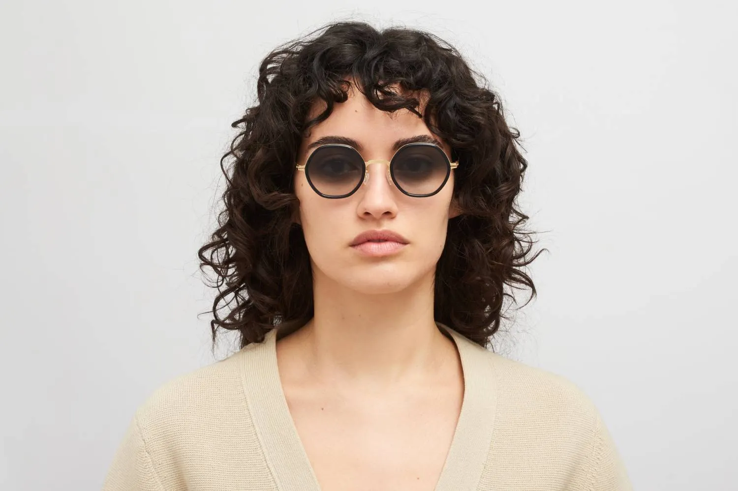Model nosi Mykita Alya sunčane naočare u boji Glossy Gold/Milky Indigo