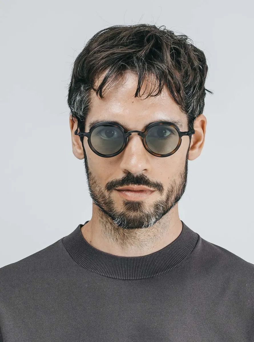 Model wearing Tavat Paladin C with black metal, tortoiseshell eye-rims and grey lenses